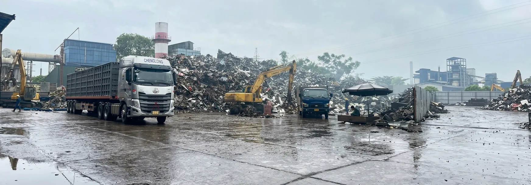 Bãi thu mua phế liệu Anh Hùng với xe tải và máy xúc